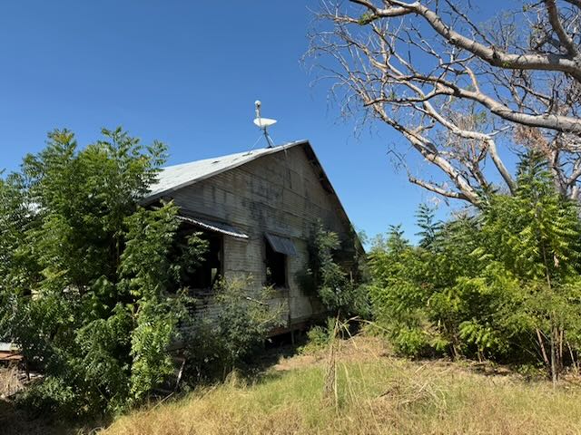 The old mission hut at Oombulgurri, built from local rock, with a boab in front of the porch